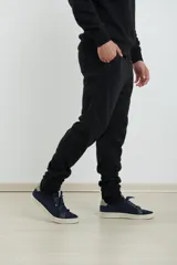 Pantalón jogging de corte deportivo con cintura elástica y cordón ajustable. Presenta puños elastizados en el ruedo y bolsillos laterales.