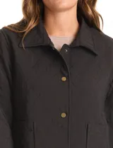 Chaqueta capitoneada de color negro con diseño de rombos, cuello con solapa, cierre frontal con botones metálicos y bolsillos delanteros.