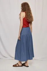 Falda midi de denim color beige, con diseño de volados y caída fluida.