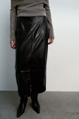 Falda midi de tiro alto con diseño de tubo, confeccionada en material con efecto piel. Presenta una abertura frontal en el bajo y cierre con cremallera oculta en la costura.