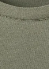 Camiseta de algodón color verde militar, con cuello redondo, hombreras y mangas cortas de diseño recto.