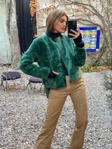 Saco de silueta recta y levemente corto, color verde oscuro. Cuenta con cuello a la base, manga larga y bolsillos laterales discretos.