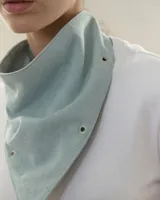 Bandana de jean color celeste claro, con diseño triangular y detalles de hojalillos metálicos en los bordes.