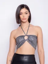 Top metalizado color champagne, sin mangas, con tirantes finos que se atan al cuello y abertura circular en el centro.