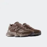 Championes New Balance modelo 9060 en color marrón, con diseño inspirado en la estética Y2K. Presentan una parte superior de malla con superposiciones de gamuza, entresuela con amortiguación ABZORB y SBS, y suela de goma con proporciones exageradas.