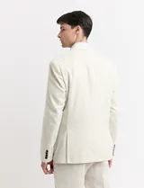Saco de lino color beige, de corte clásico, con solapas de muesca, cierre de dos botones y bolsillos de parche.