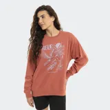 Buzo de cuello redondo color terracota, con estampa frontal de estilo playero que incluye palmeras, aves y el logo de la marca Reef.