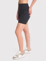 Calza corta deportiva negra de tiro alto, confeccionada en poliéster y spandex. Cuenta con banda de silicona para mayor sujeción, bolsillos laterales y certificación Bluesign.