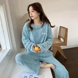 Conjunto de pijama de dos piezas confeccionado en tela de plush texturizada con diseño de rayas verticales en relieve. Incluye una remera de manga larga con cuello redondo y un pantalón de corte holgado. La remera presenta un pequeño bordado decorativo en el pecho.