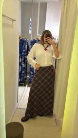 Pollera larga de corte recto con estampado de cuadros en tonos azul, gris y marrón. Presenta un diseño de tiro alto y cierre lateral.