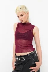 Top negro sin mangas de cuello alto, confeccionado en tela semitransparente con textura acanalada y acabado brillante.