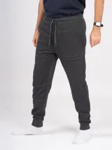 Pantalón de jogging gris melange, corte babucha, con cintura elástica ajustable con cordón y puños en los tobillos. Confeccionado en tejido de punto sin felpa.