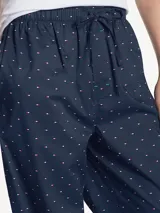 Pantalón de pijama azul marino con estampado de microbanderas rojas y blancas, cintura elástica con cordón ajustable y bragueta con botón.