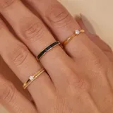 Anillo doble en oro 18k, compuesto por una alianza fina con engaste de brillantes y una alianza lisa con un brillante central.