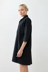 Túnica negra con bordados y bolsillos laterales.