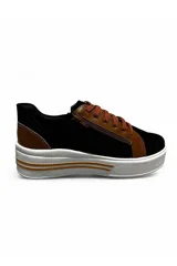 Championes deportivos Euroteens de plataforma, combinados en color negro con detalles en marrón tostado. Cuentan con cordones y cierre lateral decorativo, además de una suela gruesa blanca con línea tostada.