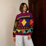 Sweater de lana merino con estampado Fair Isle en tonos azul marino, beige, naranja, verde oliva y bordó. Tiene cuello redondo y mangas largas.