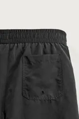 Short de baño largo en color beige, confeccionado en tejido técnico con tacto aterciopelado. Cuenta con cintura elástica ajustable con cordón, bolsillos laterales y detalle de bolsillo trasero, además de forro interior.
