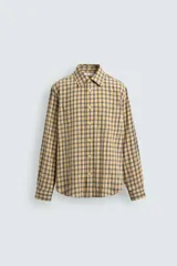 Camisa relaxed fit de algodón con elasticidad, color amarillo y gris a cuadros. Tiene cuello solapa, manga larga con puño abotonado, bajo con aberturas laterales y cierre frontal de botonadura.