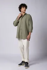 Camisa de manga larga confeccionada en lino, color verde oliva, con cuello clásico y cierre frontal de botones.