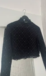 Top negro de microtul con cuello alto y mangas largas.