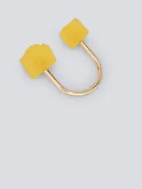 Anillo dorado con dos dados amarillos en los extremos.