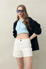 Short de algodón color beige, con diseño clásico de cinco bolsillos, tiro medio y terminación recta.