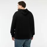 Buzo de felpa color negro con capucha, cordones ajustables y bolsillo tipo canguro frontal. Presenta puños y ruedo acanalados.