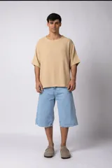 Remera de hombre, color crema, con cuello amplio y corte oversize. El tejido es liviano y texturado, similar al lino.
