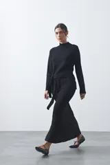 Falda midi tejida de silueta evasé, con diseño minimalista y caída fluida.