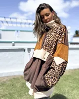 Buzo de estilo canguro con diseño de bloques de color y estampado animal print. Presenta una combinación de texturas en tonos marrón, chocolate y beige, con cuello alto, cierre frontal parcial con botones a presión y un bolsillo frontal grande con solapa.