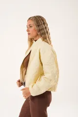 Campera color manteca con diseño acolchado de flores, cuello alto, cierre frontal con cremallera y bolsillos laterales.