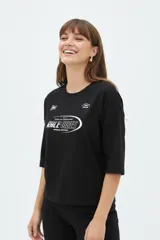 Remera negra de manga corta, cuello redondo y diseño holgado, con estampado frontal en color blanco con la inscripción "Race Vibes".