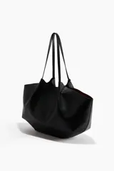 Bolso shopper de diseño slouchy, color negro, con asas largas y cierre magnético oculto. Incluye un estuche extraíble con cierre.