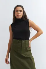 Chaleco negro de punto con cuello alto y sisas amplias.