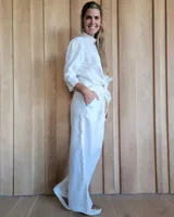 Pantalón de denim azul, de corte recto y tiro alto, con cintura elástica y cordón ajustable. Tiene bolsillos laterales.