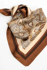 Pañuelo de poliéster de forma cuadrada, con diseño estampado estilo paisley en tonos marrones, beige y blanco, y bordes enmarcados en marrón.
