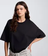 Remera oversize blanca de manga corta, con cuello redondo y diseño holgado, confeccionada en mezcla de algodón y poliéster.