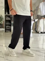 Pantalón jogging cargo color negro, sin felpa, liviano y de corte oversize, con bolsillos laterales en las piernas.