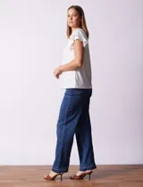 Blusa blanca de modal Rio & Rian con cuello a la base, escote en V con aplique metálico y mangas cortas con volados en capas.