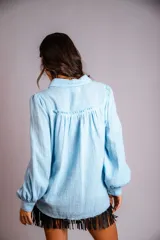 Camisa color beige de muselina con bordado en la parte delantera y mangas globo.