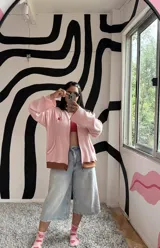 Campera de algodón premium color rosa con cierre frontal, cuello alto, bolsillos laterales y puños y dobladillo en color marrón. Tiene un bordado rojo con la letra "K" en el pecho.