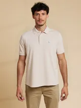 Remera polo color beige claro de corte regular, confeccionada en algodón y con logo bordado en el pecho.