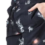Short de baño negro con estampado de hojas de palma blancas y detalles de destellos de luz en naranja y celeste.