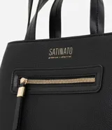 Cartera satchel mediana de Satinato en color negro, confeccionada en poliuretano. Posee estructura firme, doble asa de mano superior y correa larga ajustable para llevar al hombro o cruzada. Cuenta con un bolsillo frontal con cierre y detalles metálicos dorados.