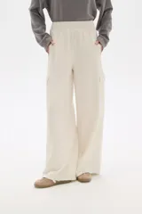 Pantalon de corte amplio y tiro alto, confeccionado en poliester, con bolsillos laterales tipo cargo.