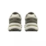 Championes Lacoste de diseño urbano con paneles superpuestos en tonos verde oliva, gris y crema. Presenta una suela robusta con amortiguación visible y detalles de la marca en el lateral y la lengüeta.