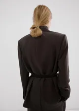 Blazer sastrero de corte recto en color gris oscuro con diseño de rayas diplomáticas, solapas con muesca, bolsillos con solapa en la parte delantera y cierre frontal de un botón.