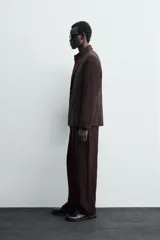Pantalón de traje straight fit color marrón oscuro, confeccionado en tejido con lana. Cuenta con bolsillos frontales, bolsillos traseros de vivo y cierre frontal con cremallera y gancho metálico oculto.