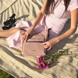 Cartera bandolera gris de formato amplio, con correa larga regulable y desmontable con inscripciones. Cuenta con cierre superior, bolsillo frontal con cierre y detalle colgante de cordones, y un bolsillo trasero con cierre.